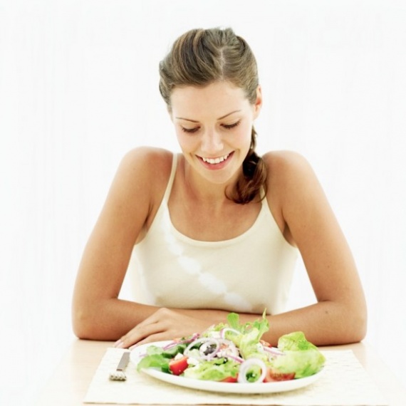 Young woman looking down at a plate of salad